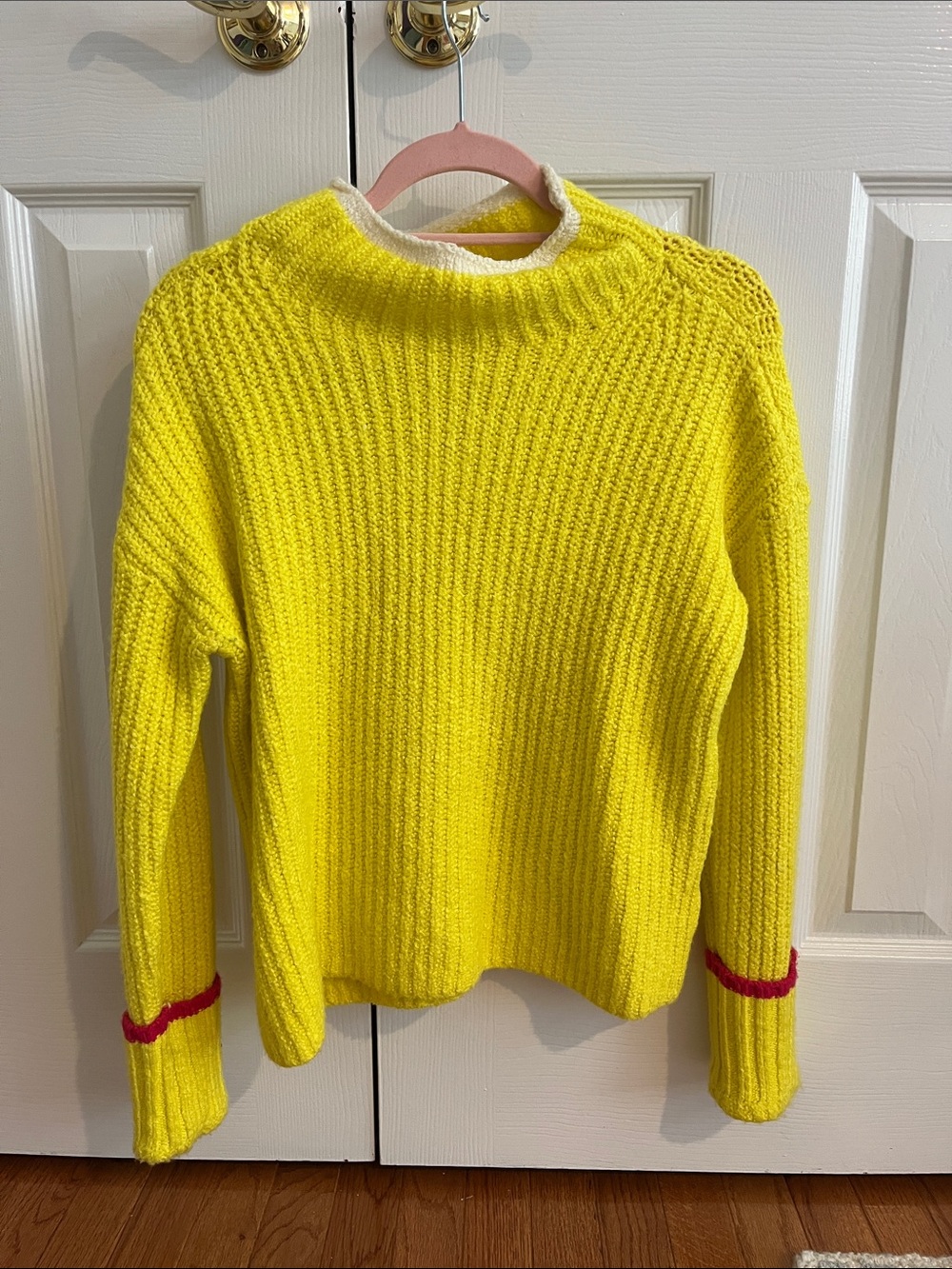 Yellow knit sweater with red trim on cuffs